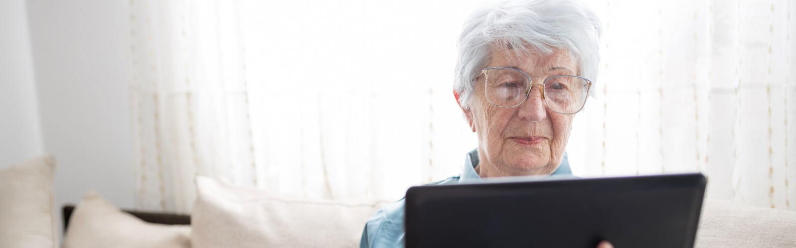 An older woman holding a tablet