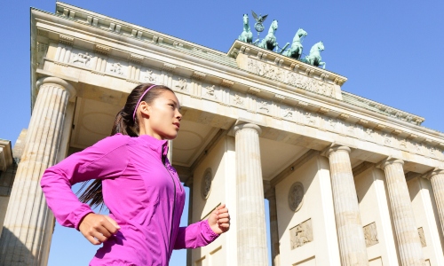 A young woman runs past the Brandenburg gate